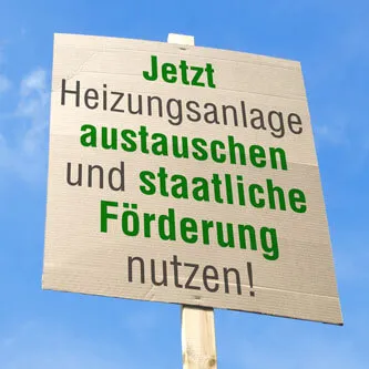 Schild mit der Aufschrift „Jetzt Heizungsanlage austauschen und staatliche Förderung nutzen!“