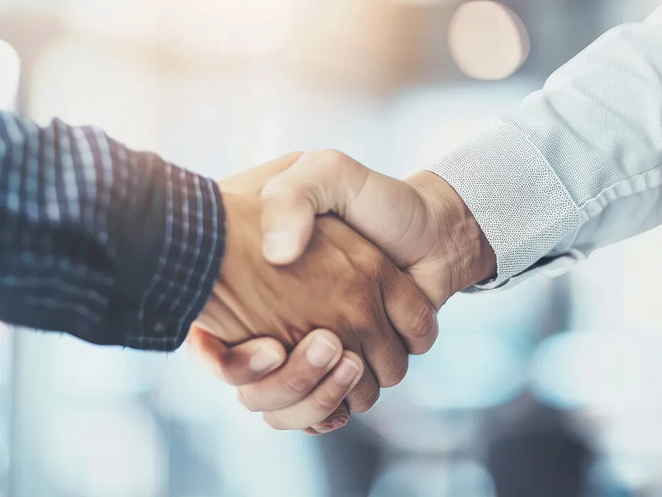 Zwei Personen besiegeln eine Zusammenarbeit per Handschlag