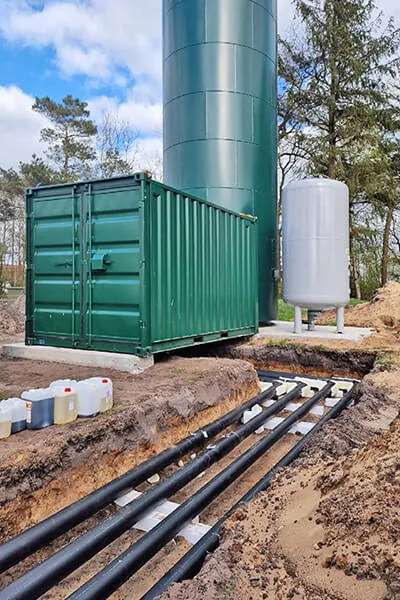 Verlegte Leitungen vor Technikcontainer, Druckbehälter und Pufferspeicher