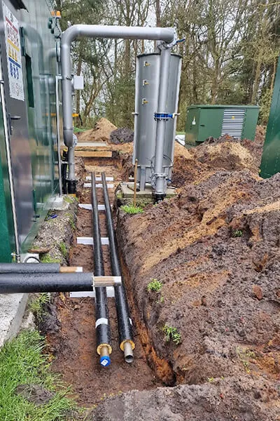 Leitungsgraben mit gedämmten Rohren neben dem Technikcontainer