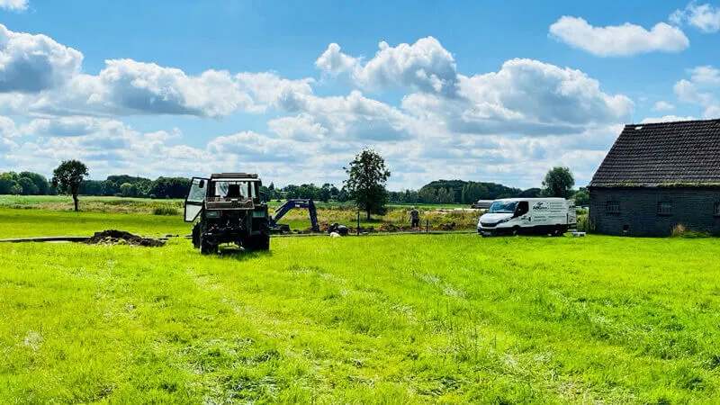 Baustelle der Nahwärmeleitung auf einer Wiese in Ohrwege mit Bagger und Servicewagen