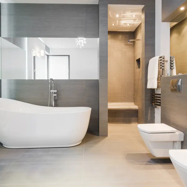 Badezimmer mit freistehender Badewanne, wandhängendem WC und Bidet