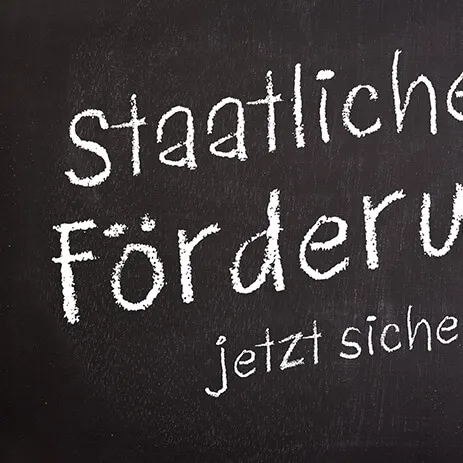 Kreidetafel mit der Aufschrift „Staatliche Förderung jetzt sichern!“